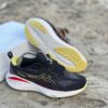 Black ASICS running shoes with a nice yellow and red outline.